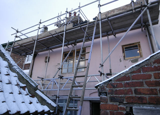 Scaffolding against the pink cement render